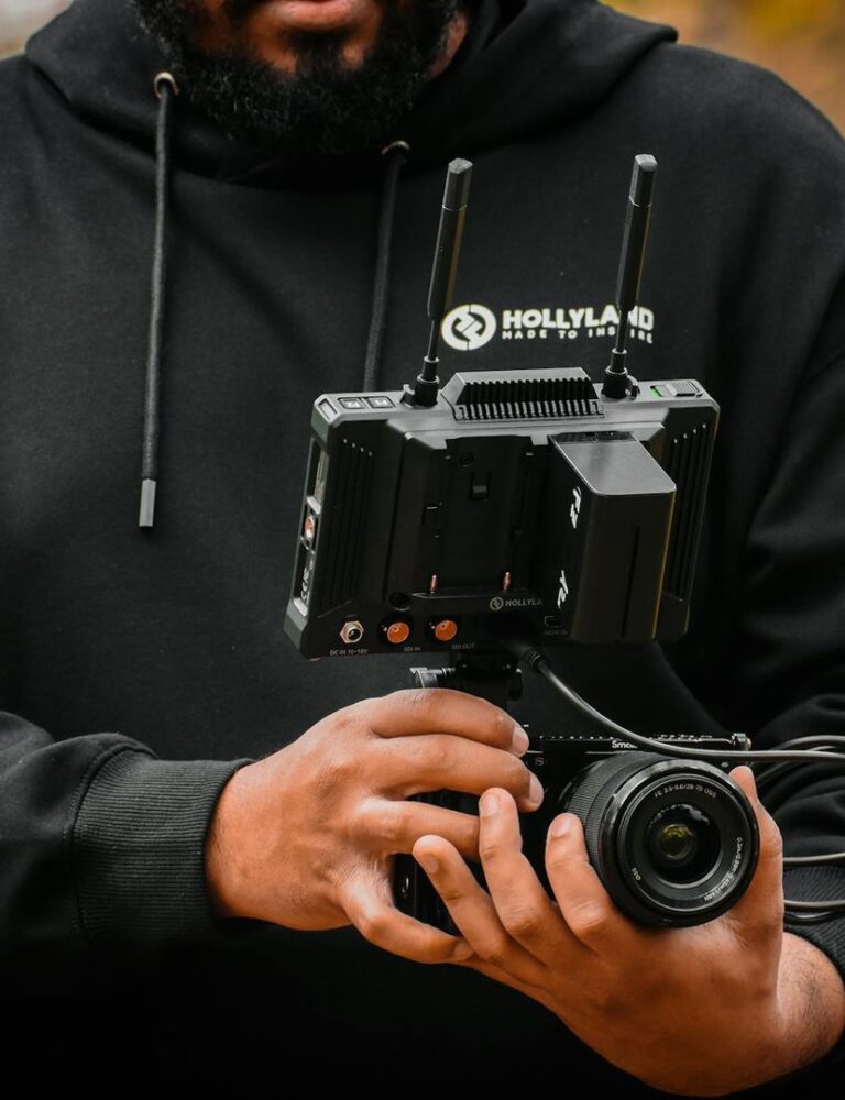 Un vidéaste manipule une caméra équipée d'un moniteur de contrôle Hollyland.