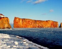 Rocher Percé et maison en bord de mer sous un ciel bleu