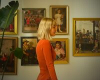 Visiteuse devant des tableaux anciens dans une galerie d’art