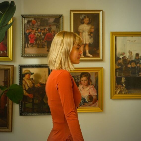 Visiteuse devant des tableaux anciens dans une galerie d’art